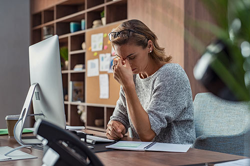 women stressed at computer in office
